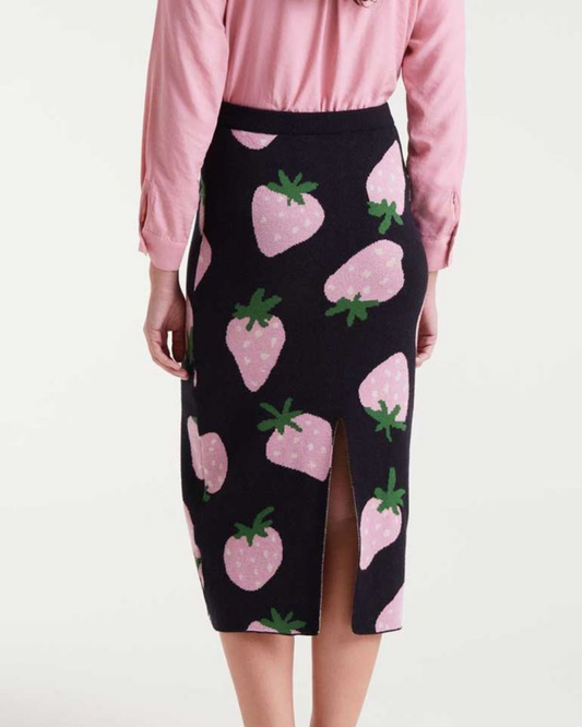 Black pencil skirt with pink strawberry pattern worn by a person against a white background