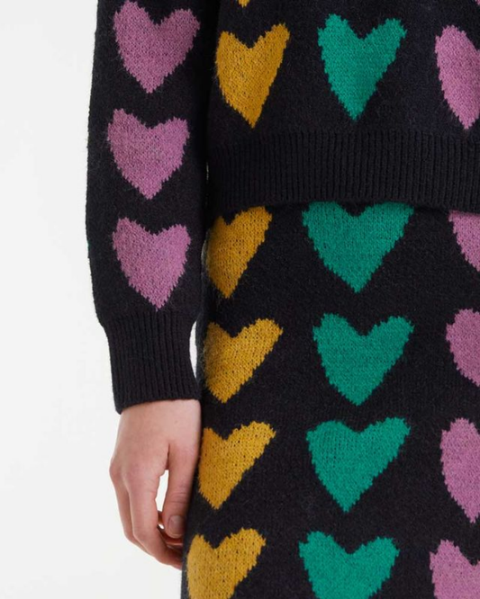 Black sweater with colorful heart patterns on a white background