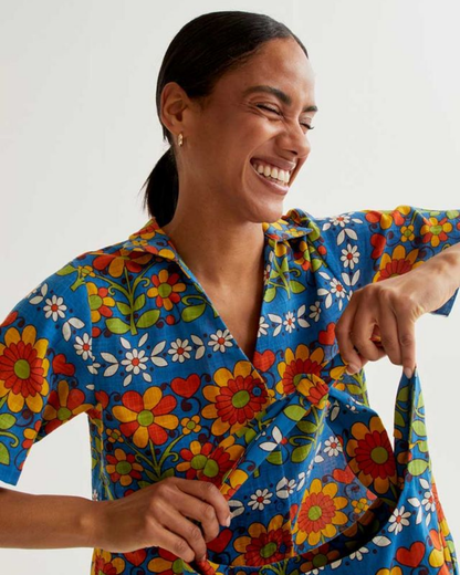 Woman wearing a colorful floral shirt against a white background