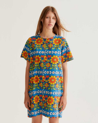 Woman wearing a colorful floral dress on a plain background