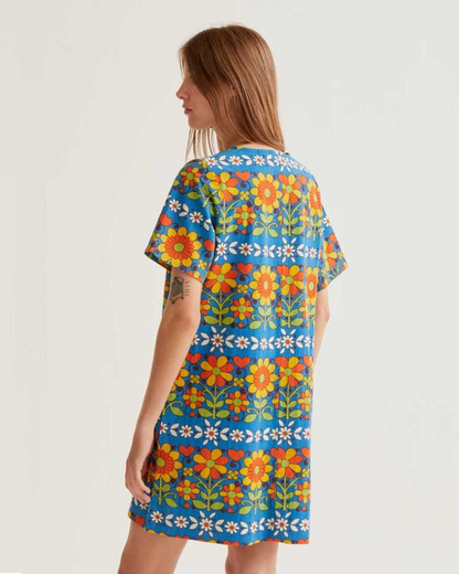 Woman wearing a colorful floral dress on a plain background