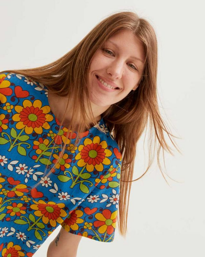 Woman wearing a colorful floral dress against a white background