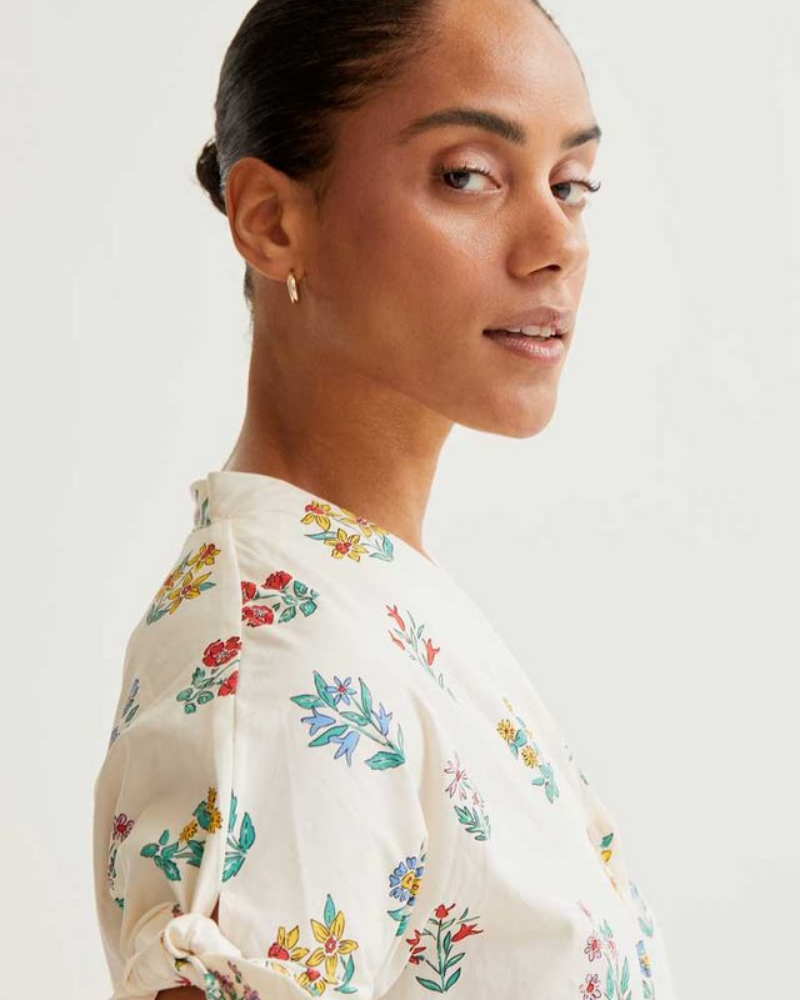 Woman wearing a floral blouse against a white background