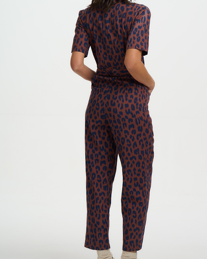 Person wearing a leopard print jumpsuit on a white background