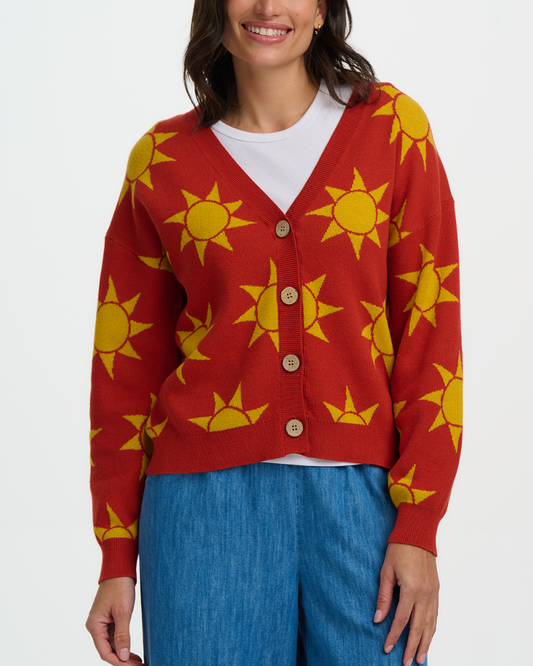 Person wearing a red cardigan with yellow sun patterns on a white background