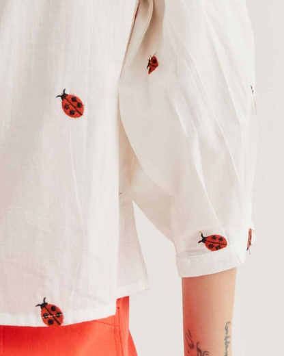 White shirt with ladybug patterns on a white background