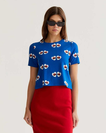 Woman wearing a blue top with a pattern and a red skirt on a white background
