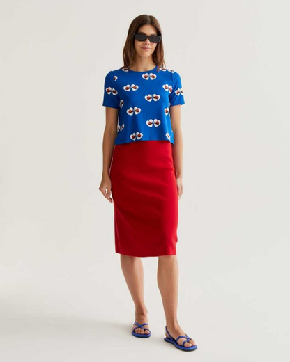 Woman wearing a blue top with a red skirt on a white background