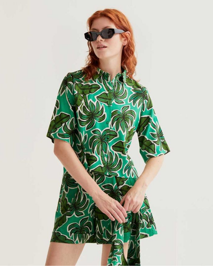Woman wearing a green and white patterned dress on a plain background