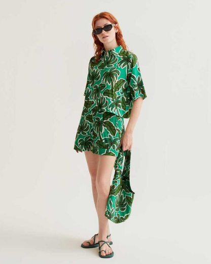 Woman wearing a green and white patterned dress on a white background
