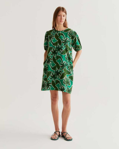 Woman wearing a green patterned dress on a white background