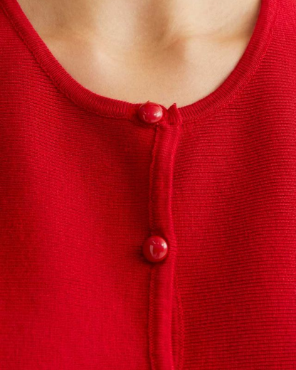 Close-up of a red garment with buttons on a blurred background