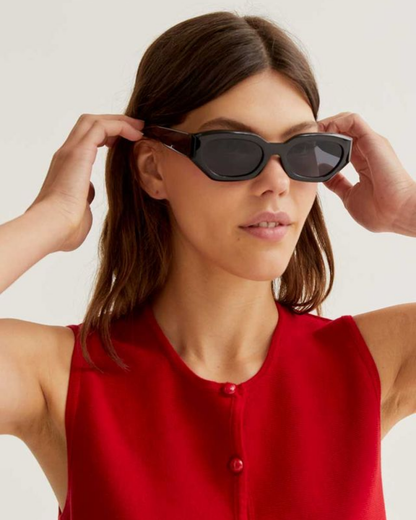 Woman wearing black sunglasses with a plain background