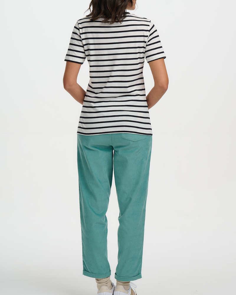 Person wearing a black and white striped shirt and teal pants on a white background