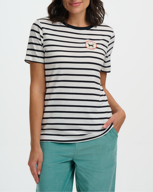 Woman wearing a black and white striped t-shirt with a small logo, standing against a plain background.