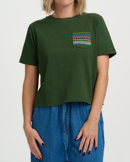 Person wearing a green t-shirt with a colorful pocket design on a white background